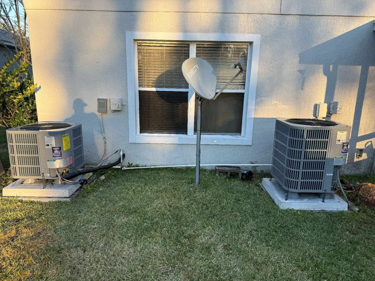 Two new AC condensers installed on concrete pads at a Brevard County home